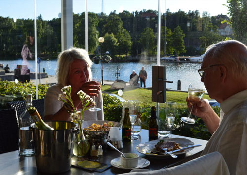 Två personer sitter på uteserveringen och äter